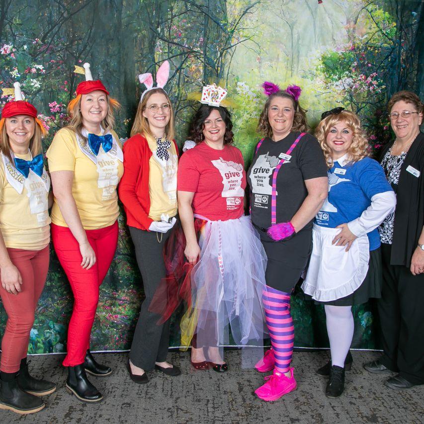 UWNEMN staff at 2024 Power of the Purse event, dressed as Alice in Wonderland characters