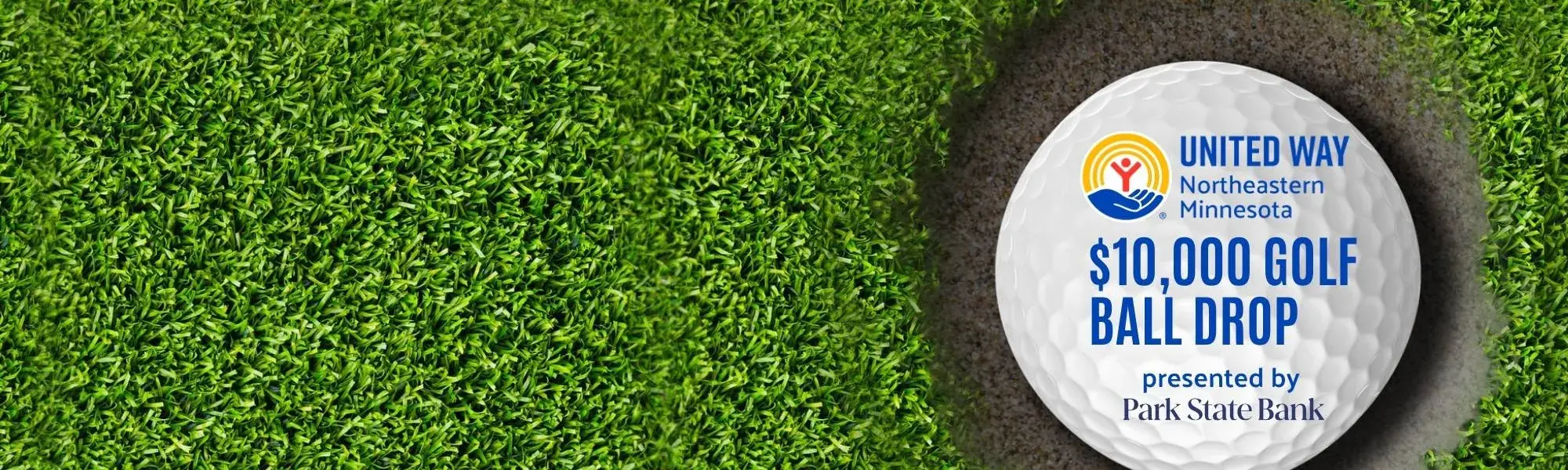 Golf ball in hole. On golf ball is text: United Way of NE MN's $10,000 Golf Ball Drop presented by Park State Bank
