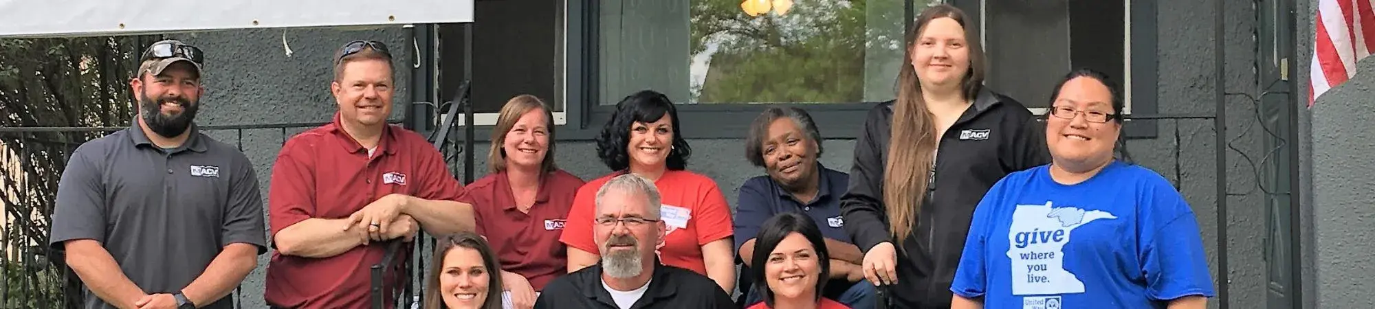 UWNEMN staff and volunteers sit on steps of Veterans Transitional Home with MACV staff