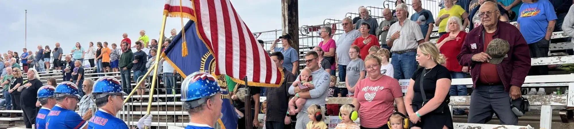 Veterans and their loved ones smile in the Hibbing Raceway stands at a United for Veterans Connections activity
