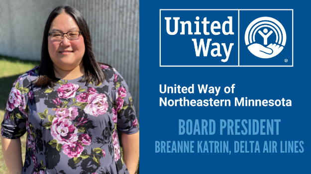 Breanne Katrin, new board president, stands outside of UWNEMN building in a floral shirt