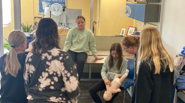 Students practice CPR for an American Red Cross Babysitter Training at United Way of Northeastern Minnesota